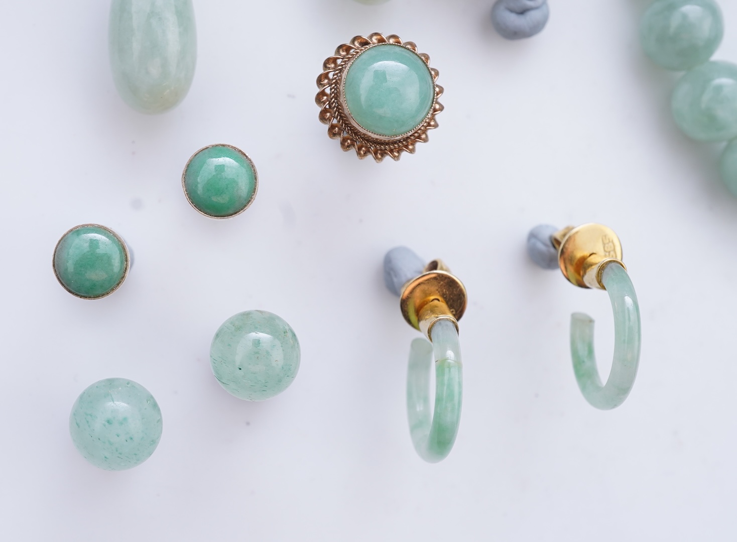 A collection of jadeite jewels, comprising: a bead bracelet with a silver clasp; together with three pairs of studs; one pair of hoop studs, one broken and restuck; and one pair of drop earrings, each set with jadeite, m